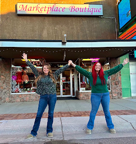 Two people outside The Marketplace Boutique storefront